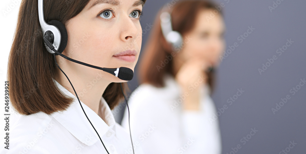 Call center. Group of operators at work. Focus on young brunette woman. Business concept Call center. Group of operators at work. Focus on young brunette woman. Business concept