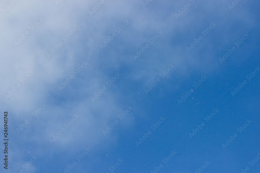 Fototapeta premium Blue sky. Blue sky with light clouds. From the blue sky it is snowing. Winter bright blue sky
