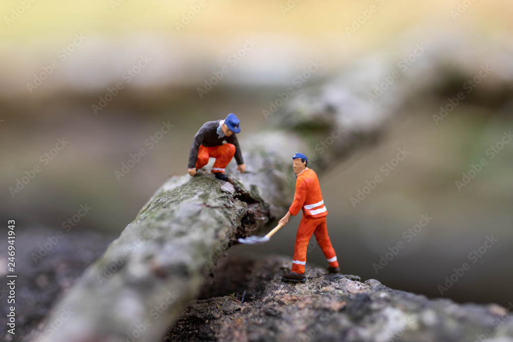 Miniature people: Logger wood cutting for house construction, using image for business concept. Miniature people: Logger wood cutting for house construction, using image for business concept.