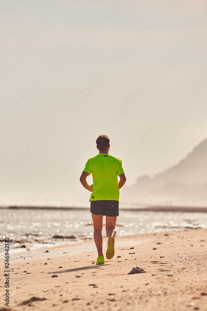 Man running / jogging on a tropical exotic beach.