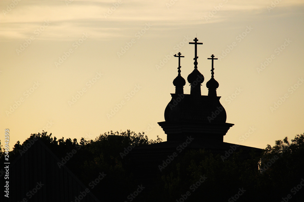 The silhouette of cupolas of Wooden Saint George Church in Kolomenskoe against bright sunset sky	