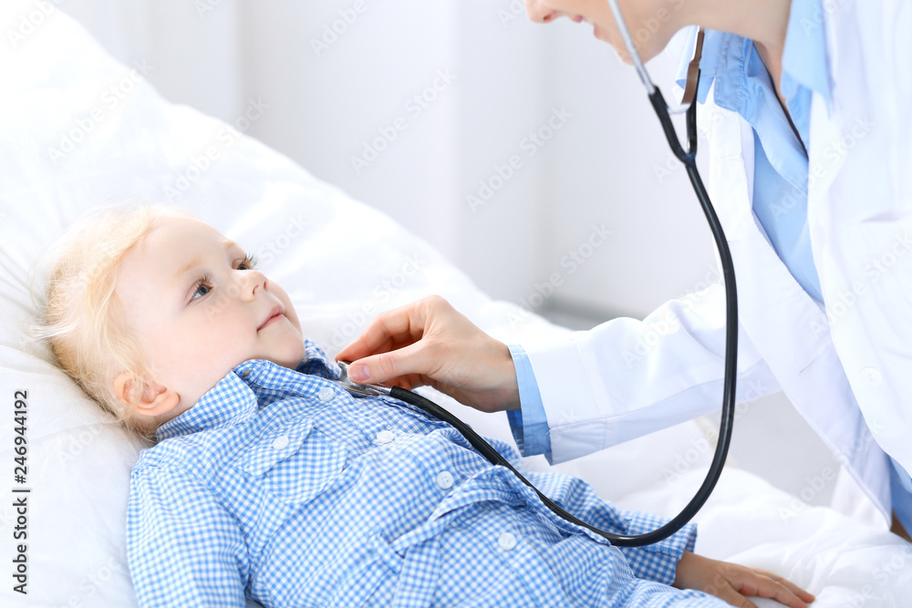 Doctor and a little blonde girl. Usual health exam. Medicine and healthcare concept Doctor and a little blonde girl. Usual health exam. Medicine and healthcare concept