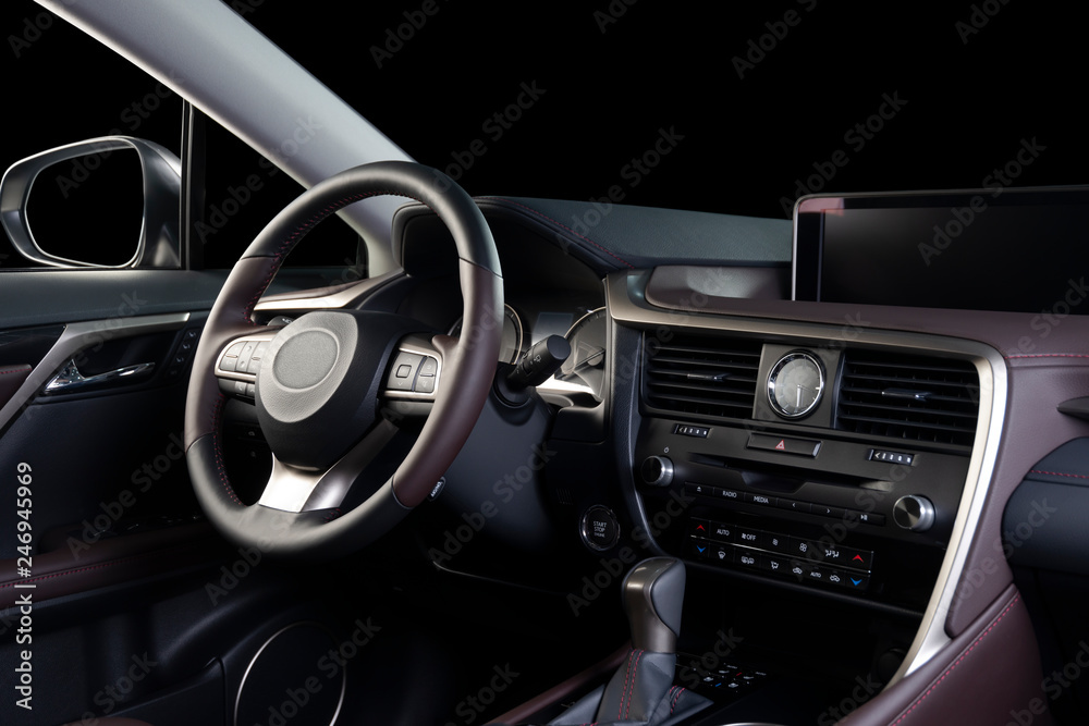 Car interior luxury. Beige comfortable seats, steering wheel, dashboard, climate control, speedometer, display, wood decoration, isolated on black, clipping path included