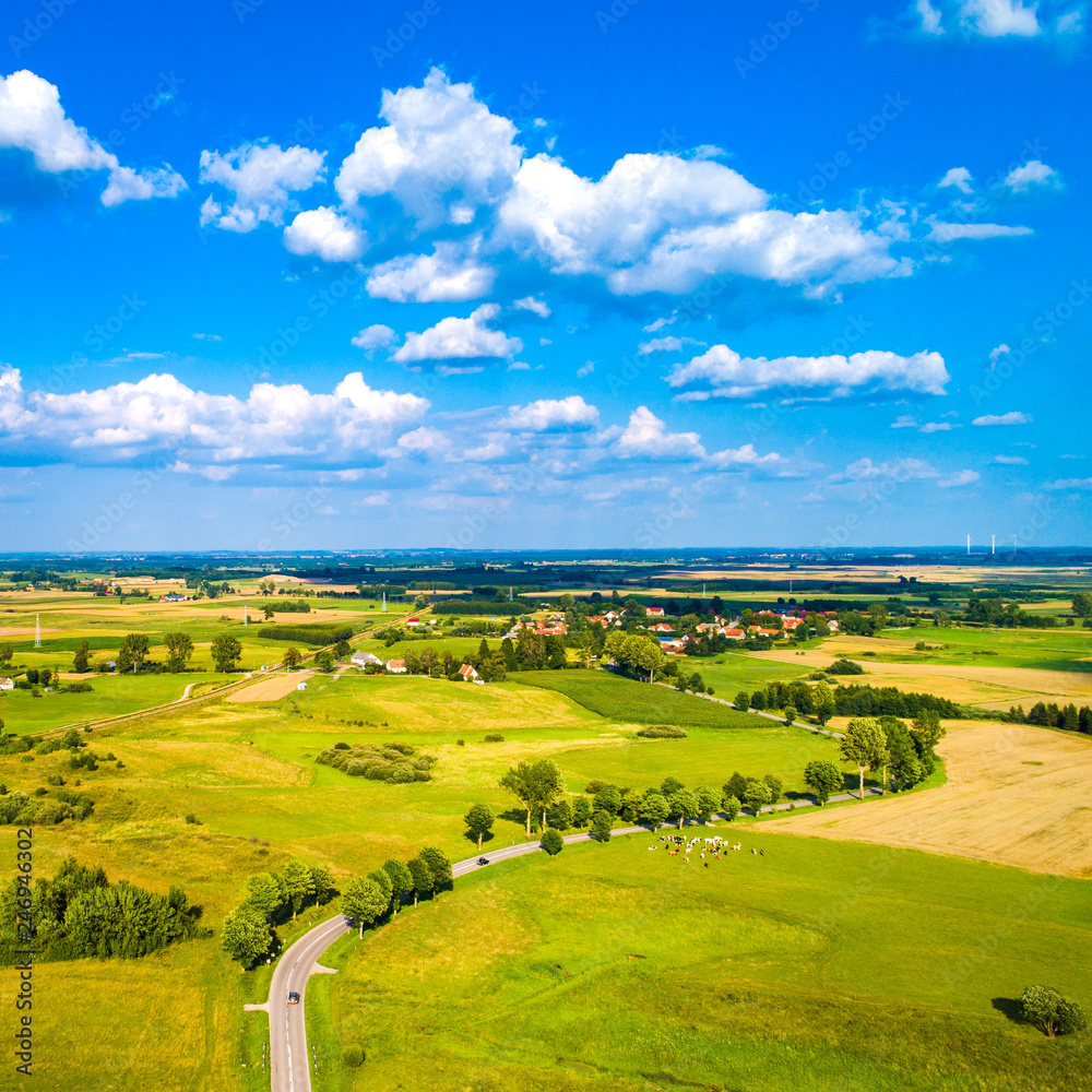 Obraz premium Aerial view of a country road between agricultural fields in Europe, Germany. Beautiful landscape. Captured from above with a drone
