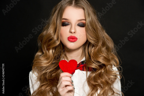 Valentine's Day. Beautiful girl with heart. Woman with red shiny heart. 