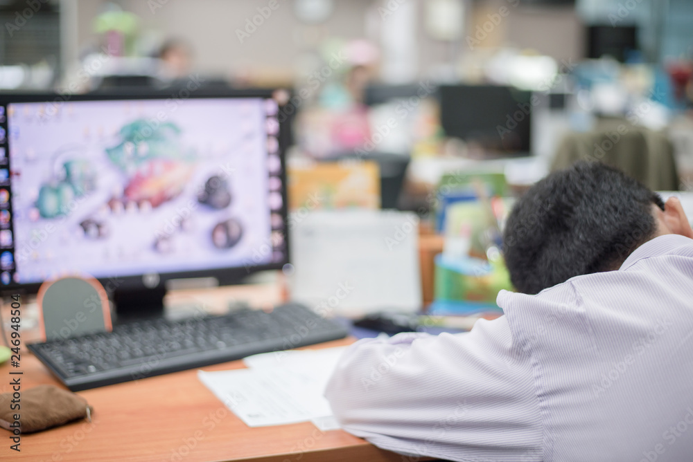 Stressful male entrepreneur sleeping on the table with computer and documents Stressful male entrepreneur sleeping on the table with computer and documents