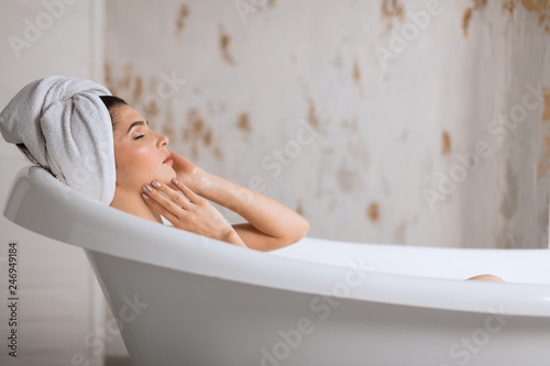 Young brunette  european woman treats herself to a comforting warm aroma bath  release tension  gets free her body of the everyday strains and stress