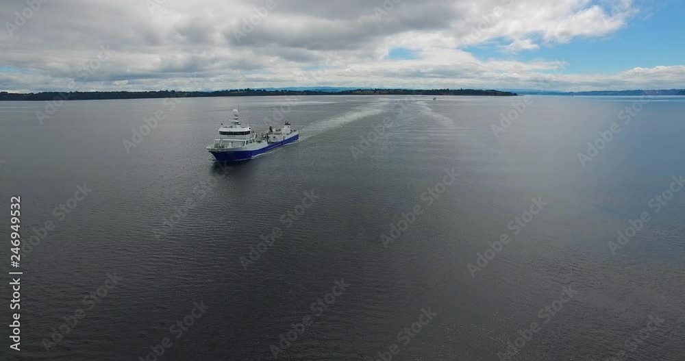 Aerial view with drone of a wellboat sailing through the archipelago of Chiloé Aerial view with drone of a wellboat sailing through the archipelago of Chiloé