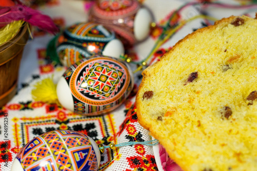 Closeup Easter composition of painted eggs, cake with raisins on embroidered towel sewed in Ukrainian style. Traditions of celebraiting Easter in Ukraine. © Nataliya Pokrovska