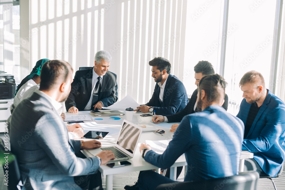  onstruction company management board members headed by grey-haired caucasian director analyzing company statistics during office meeting, consider stats diagrams making predictions