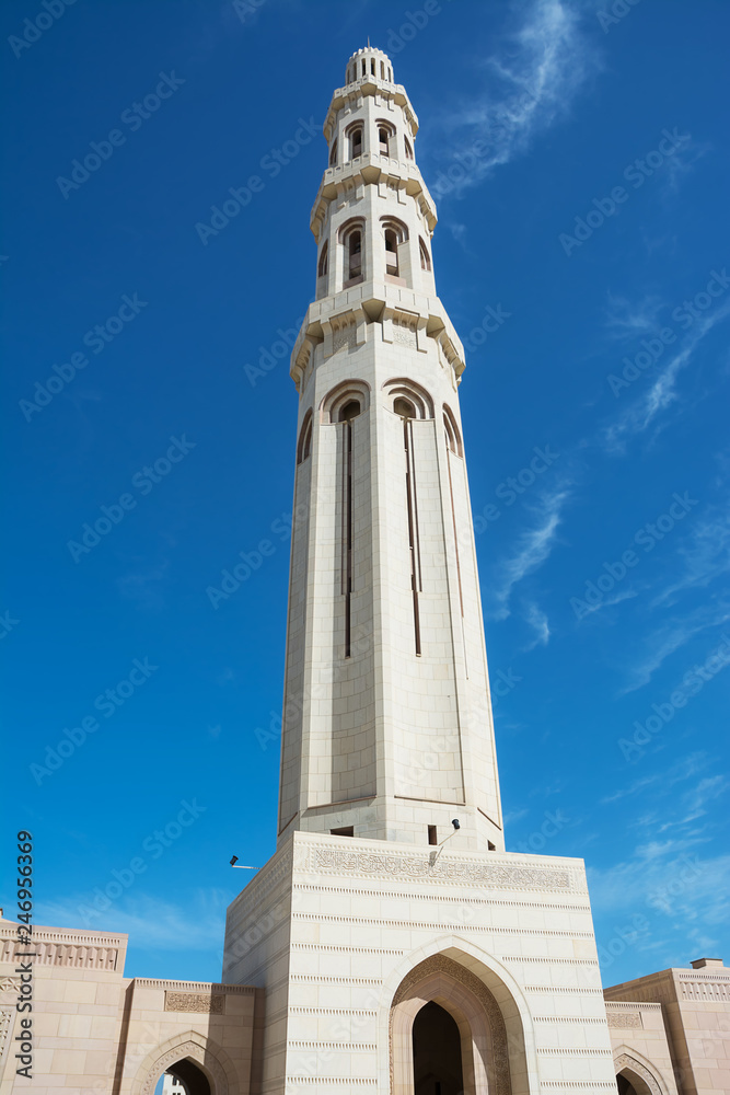 Minaret of the Muscat Grand Mosque silhouetted in the blue sky