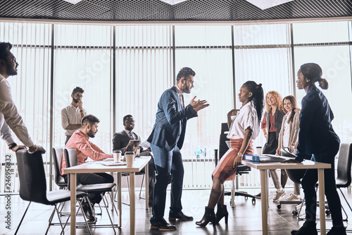 boss is scolding female employee in fron of colleagues. conflictual dialogue. conflictual situation at workplace. agression.