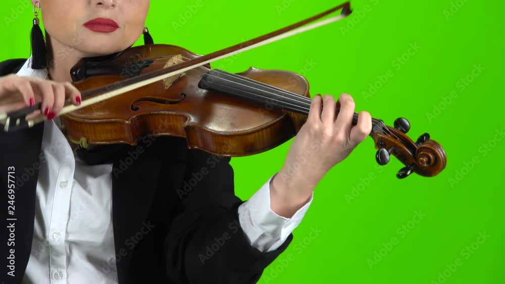 Girl in a jacket playing the violin. Green screen. Close up Girl in a jacket playing the violin. Green screen. Close up