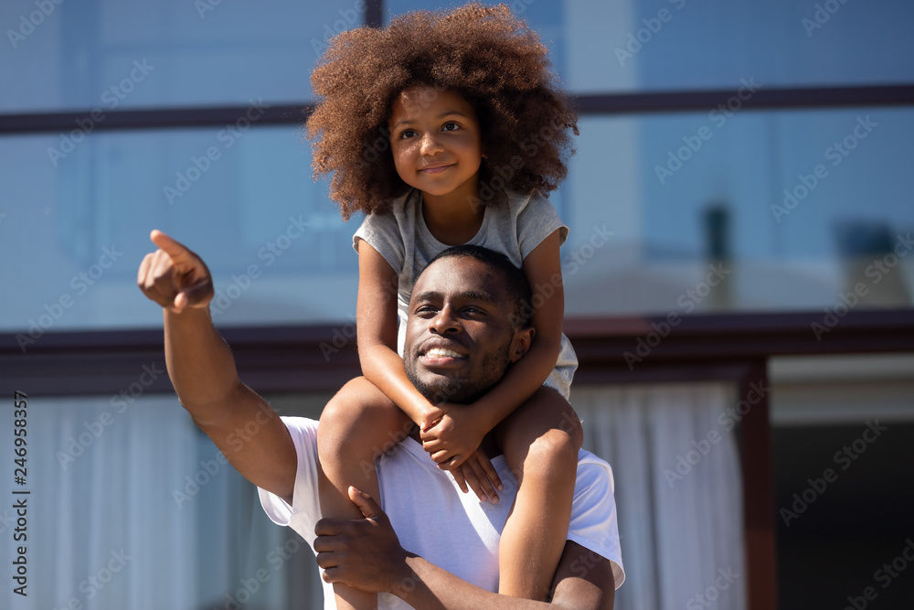 Happy single african dad holding cute kid daughter on shoulders ...