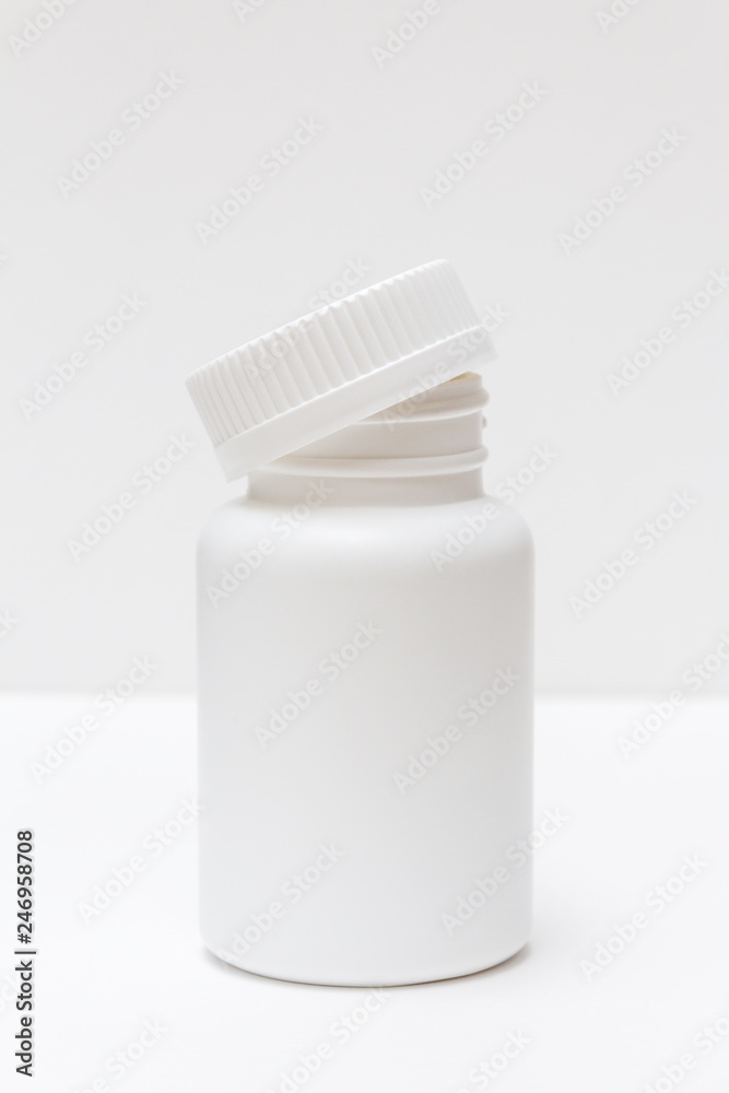 white plastic bottle with cap for pills on a light background white plastic bottle with cap for pills on a light background