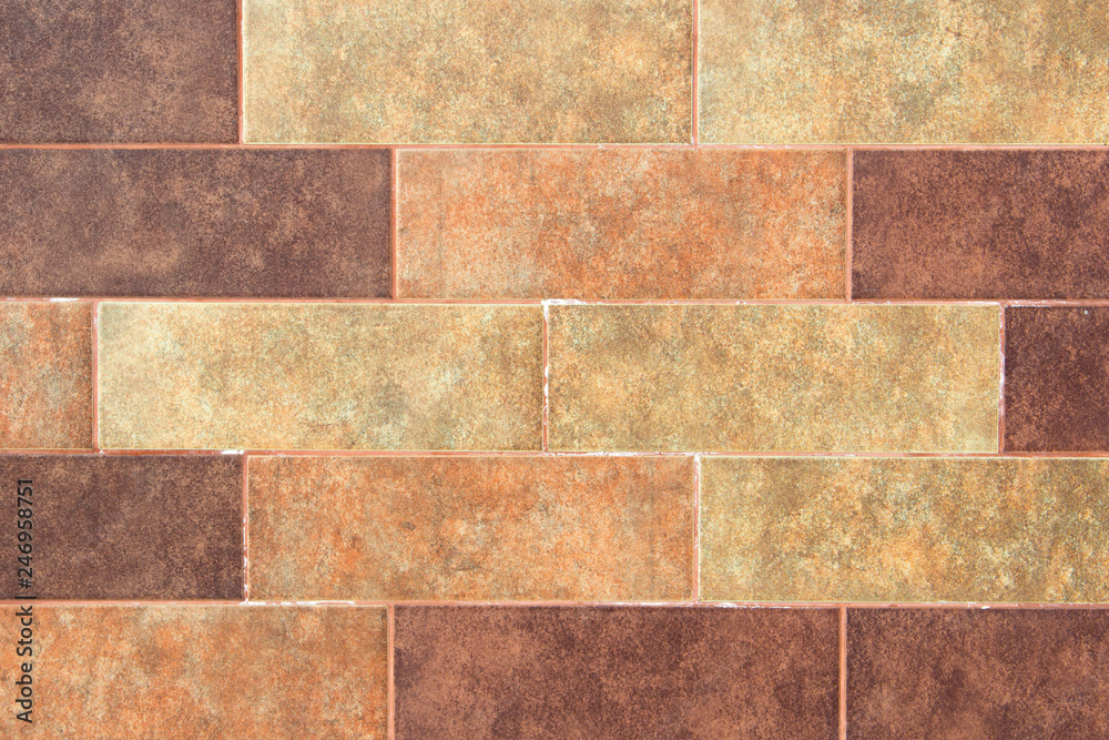 The texture of a brick wall of decorative multicolored rectangular bricks with noise, scratches and stains. The texture of a brick wall of decorative multicolored rectangular bricks with noise, scratches and stains.