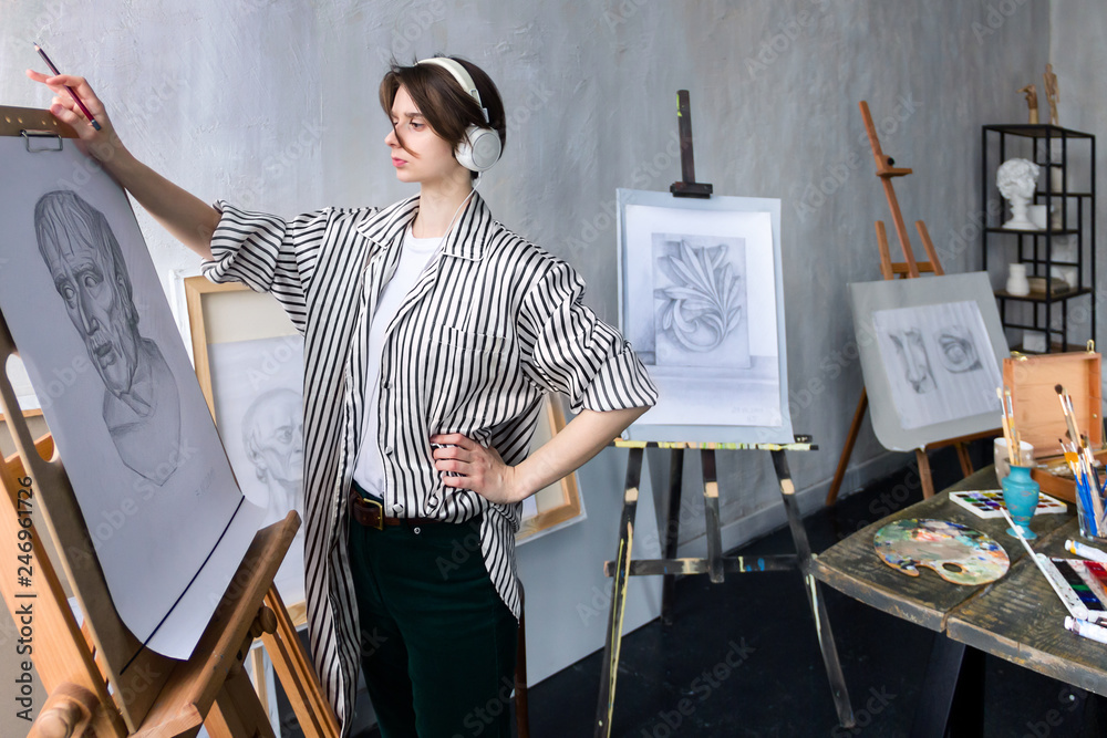 Modern young freelancer artist sculptor woman in headphone creates new art masterpiece drawing