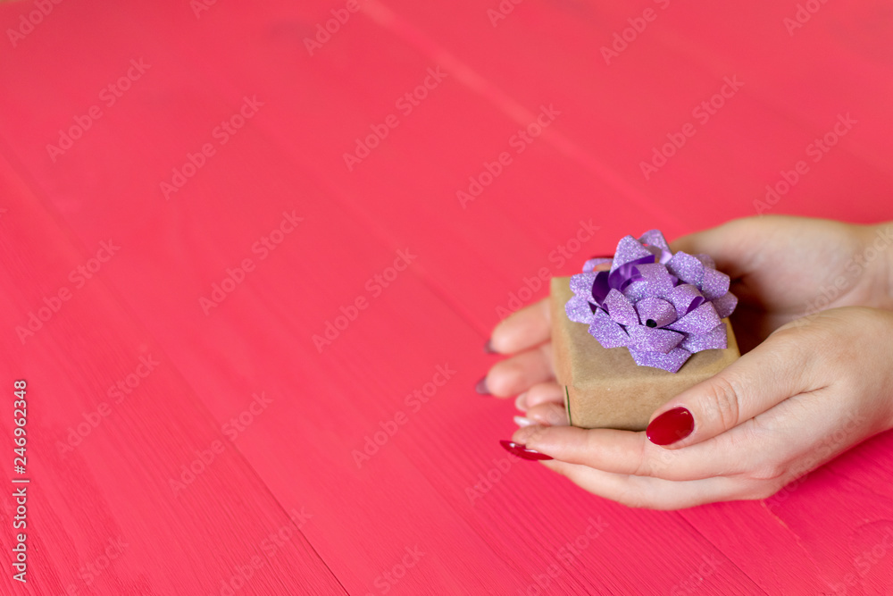 female hands give present on wooden red background female hands give present on wooden red background