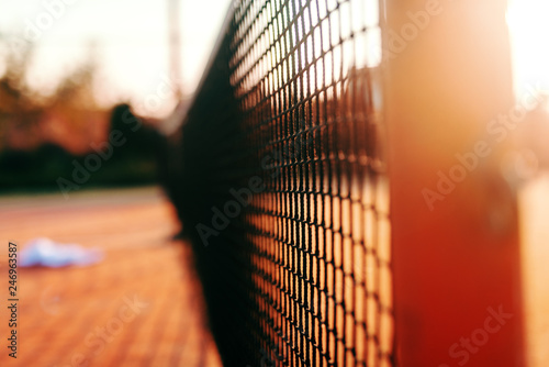 Close up of net on tennis court. Picture taken in the morning at summer.