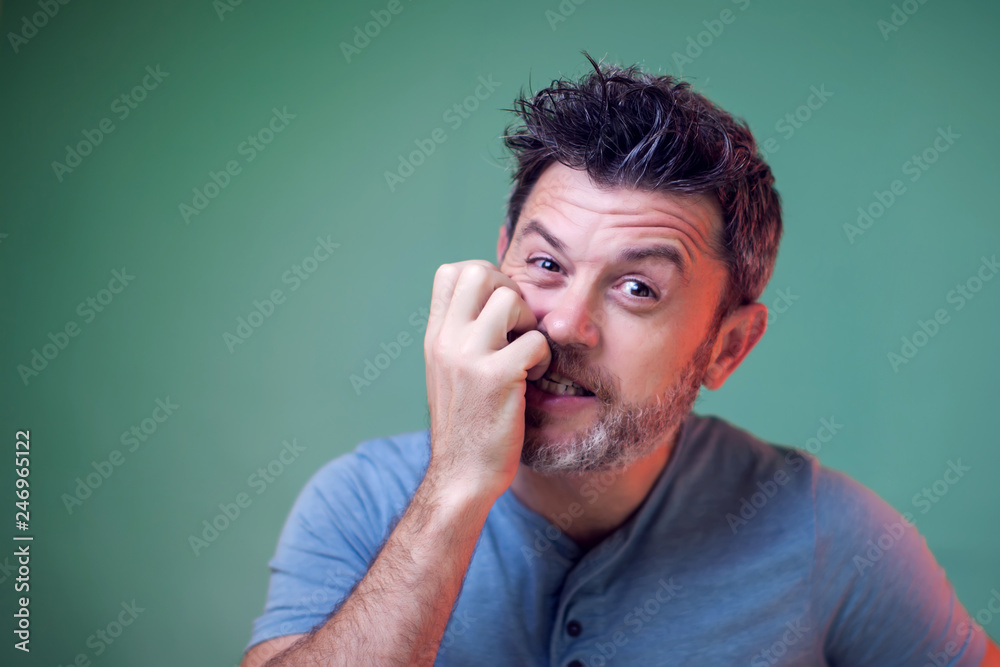People and emotions - a portrait of nervous man bit his nails People and emotions - a portrait of nervous man bit his nails