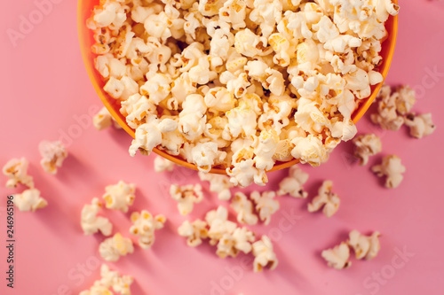 A bowl with popcorn on pink background.