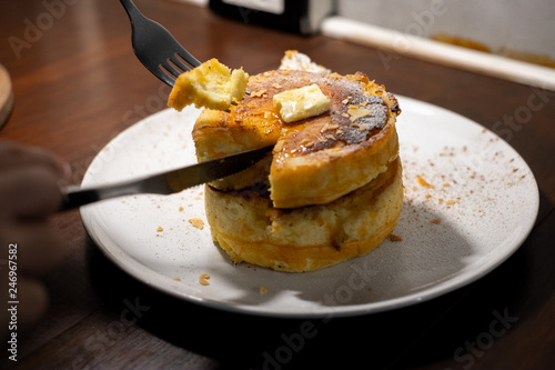 enjoy eating with forkFluffy Japan souffle pancakes, hotcakes with honey syrup and butter light concrete