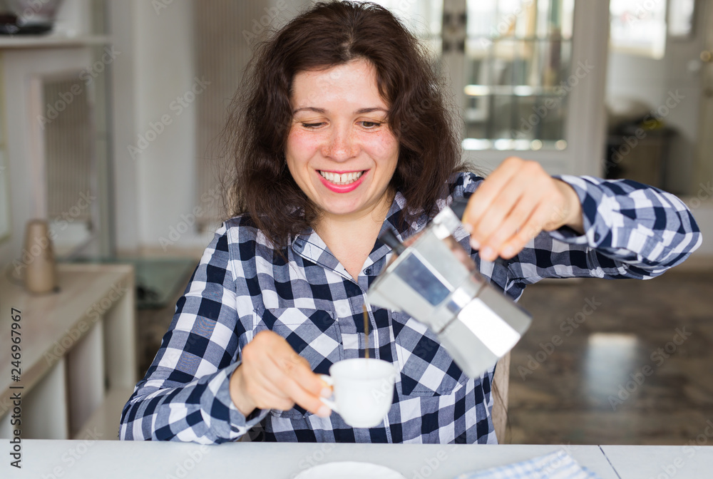 Cafe, drinks and meal concept - young woman with coffee pot pouring coffee in cup Cafe, drinks and meal concept - young woman with coffee pot pouring coffee in cup