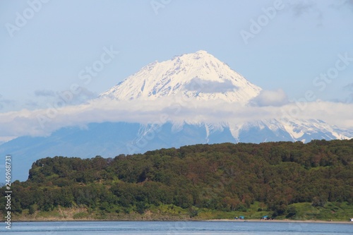 Koryaksky volcano rises above the coastline of the Kamchatka Peninsula. Koryaksky or Koryakskaya Sopka is an active volcano on the Kamchatka Peninsula in the Russian Far East. photo