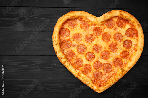 Pizza heart for Valentine's Day romantic concept copy space on rustic dark black background. Top View. Flat lay