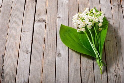 bouquet of lily of the valley on old weathered wooden table background © tstock
