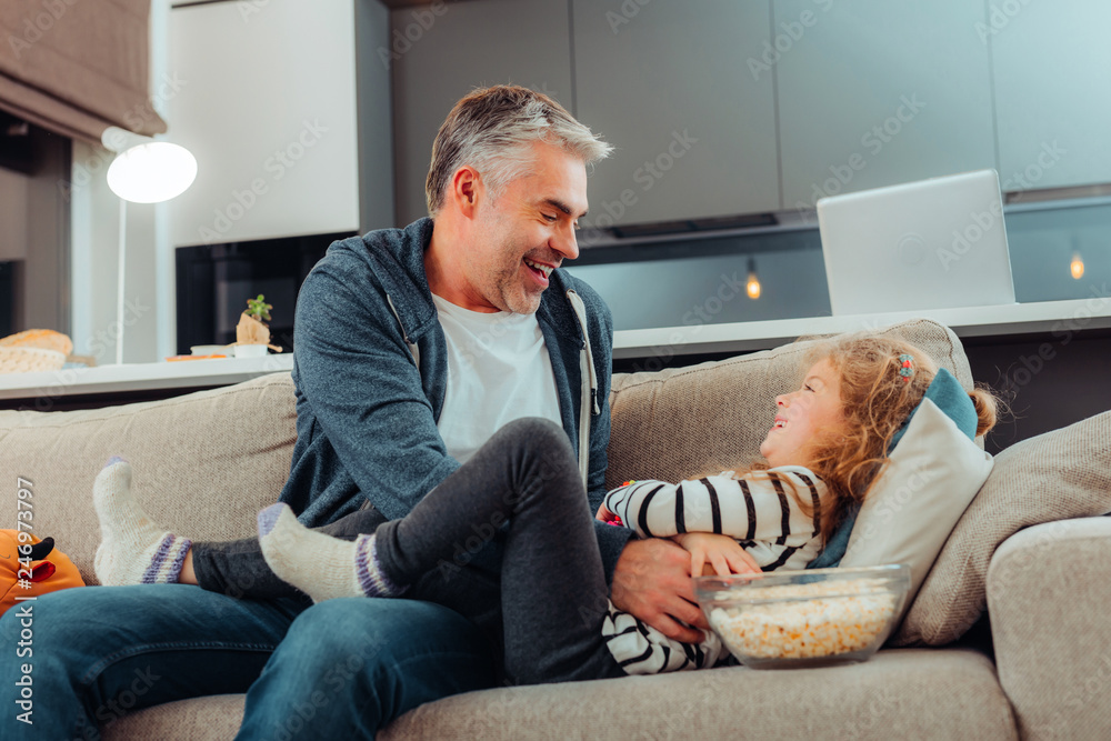 Adorable small long-haired girl and her father laughing happily