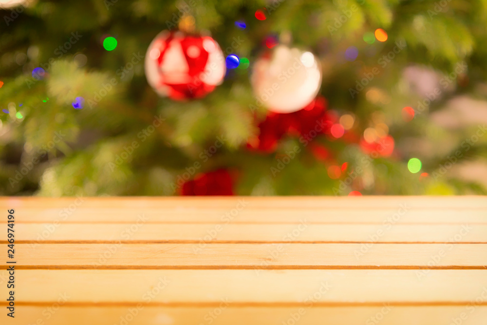 Christmas holiday background. Empty wooden table top with blurred christmas tree decoration