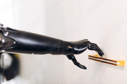 prosthetic black arm holding a handle, artificial arm touching the handle. close up cropped photo photo