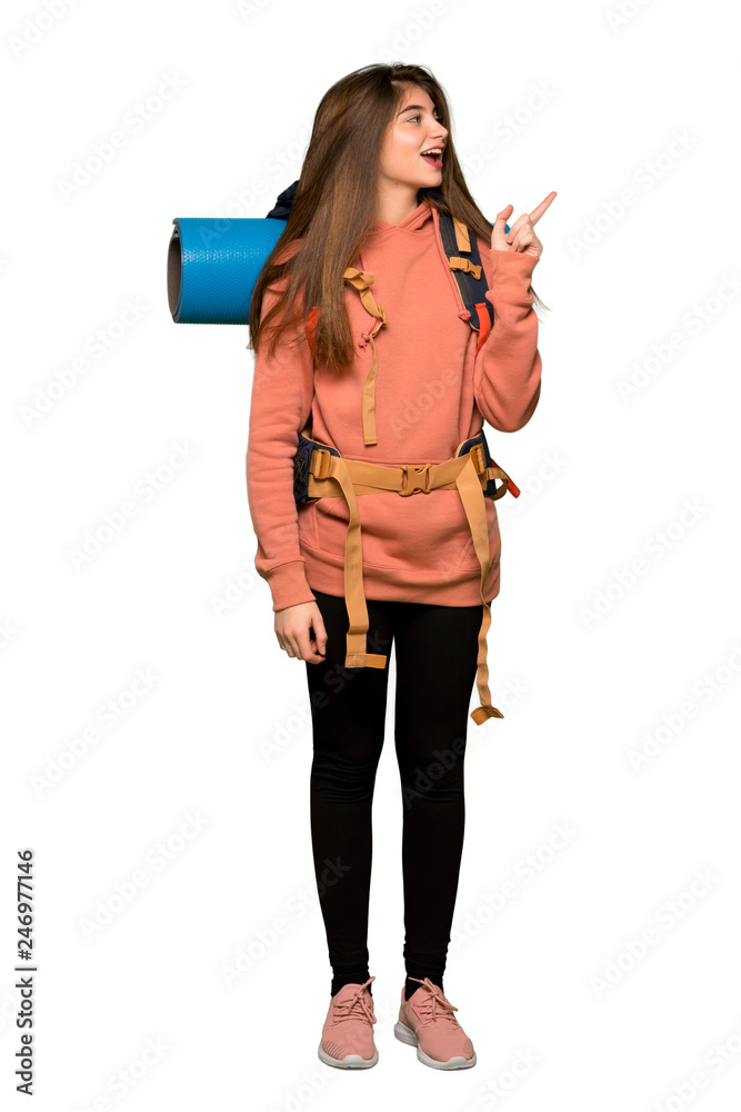 Full-length shot of Hiker girl pointing finger to the side in lateral position on isolated white background