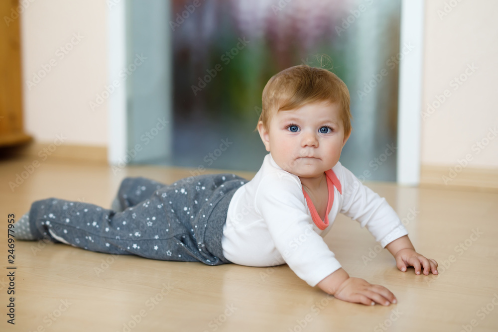 Little cute baby girl learning to crawl. Healthy child crawling in kids room. Smiling happy healthy toddler girl. Cute toddler discovering home and learning different skills Little cute baby girl learning to crawl. Healthy child crawling in kids room. Smiling happy healthy toddler girl. Cute toddler discovering home and learning different skills