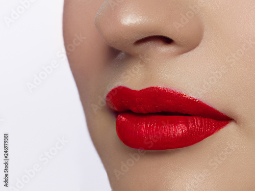 Close up view of beautiful woman lips with red matt lipstick. Open mouth with white teeth. Cosmetology  drugstore or fashion makeup concept. Beauty studio shot. Passionate kiss