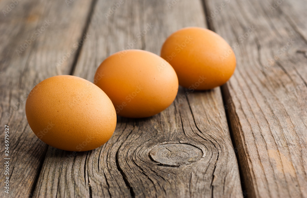 three eggs on weathered wooden table three eggs on weathered wooden table
