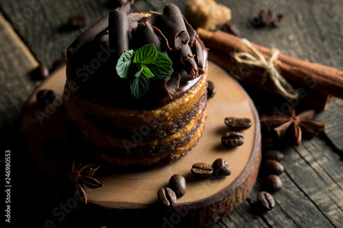 Chocolate cakes on black slatter board with mint, coffee beans on dark background, closeup photo. Fresh, tasty dessert food concept.  photo