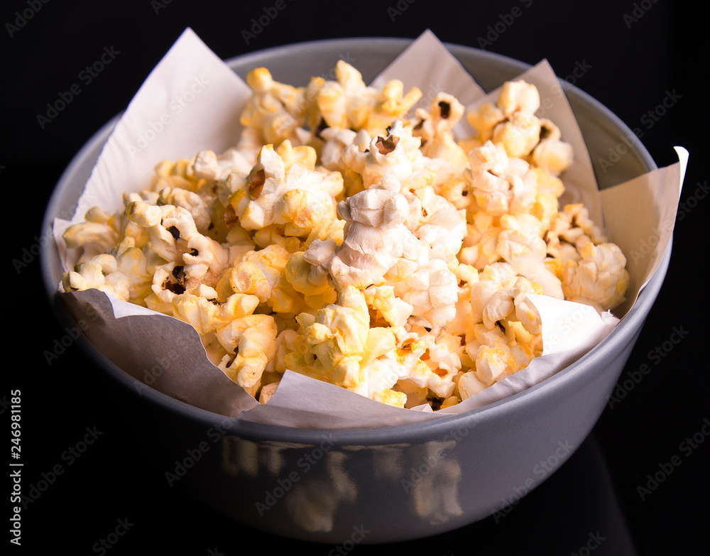popcorn in a cup and a glass on a dark background popcorn in a cup and a glass on a dark background