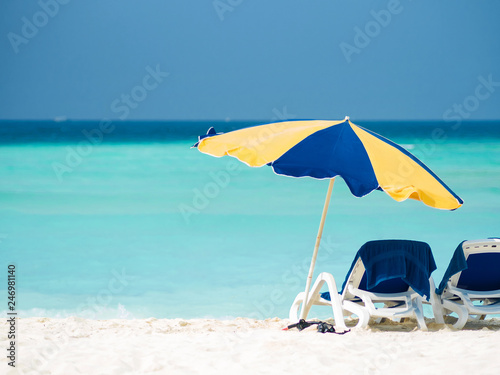 Fototapeta Naklejka Na Ścianę i Meble -  Rest on a tropical island. Lie in a sun lounger on the beach under an umbrella