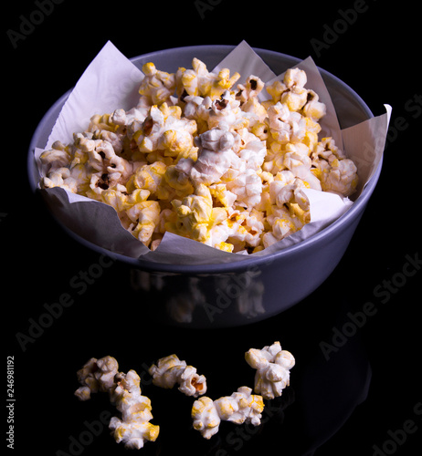 popcorn in a cup and a glass on a dark background photo