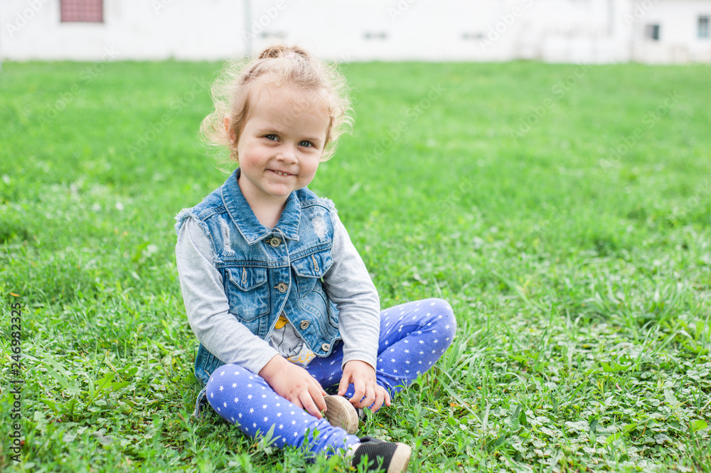 Happiness little girl sitting on the grass in field Happiness little girl sitting on the grass in field
