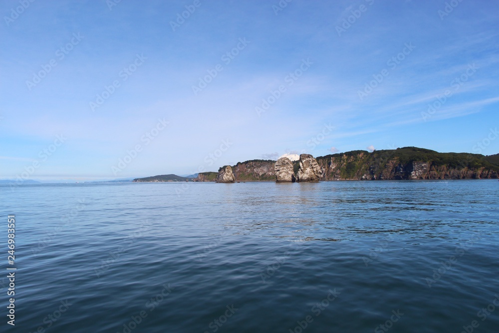 View of Tri Brata with Koryaksky volcano's top in the background. Tri Brata (Russian: Три Брата; literally: View of Tri Brata with Koryaksky volcano's top in the background. Tri Brata (Russian: Три Брата; literally: