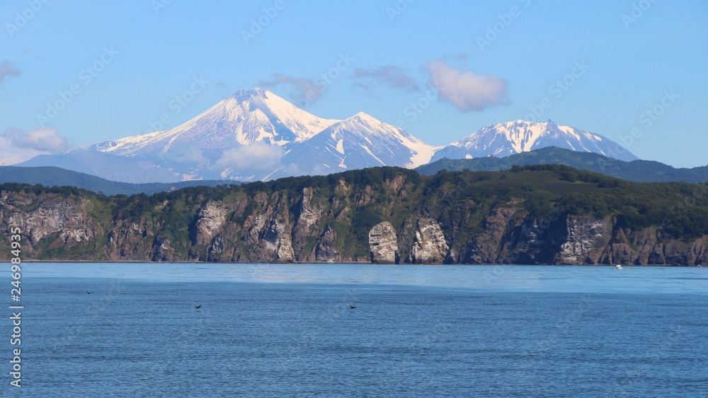 View of Tri Brata with Avachinsky and Kozelsky volcanoes in the background. Tri Brata (Russian: Три Брата; literally: View of Tri Brata with Avachinsky and Kozelsky volcanoes in the background. Tri Brata (Russian: Три Брата; literally: