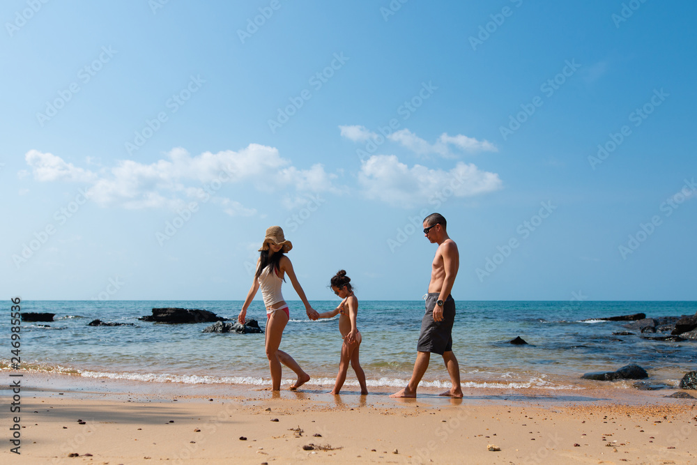 ビーチで遊ぶ父と母と娘