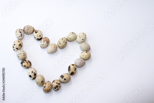 heart of quail eggs isolated on white . easter background