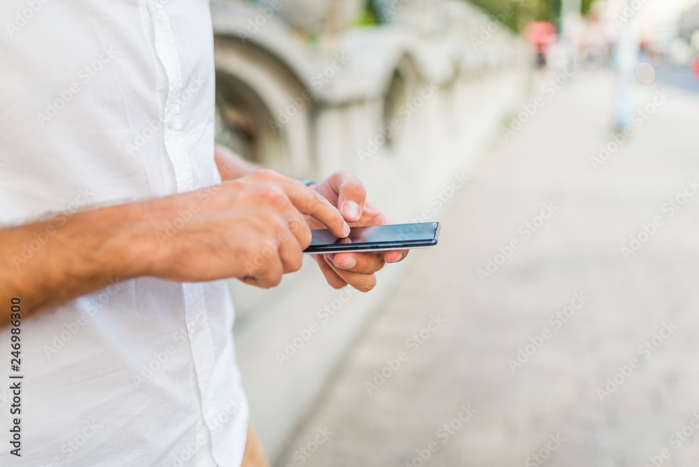 Student sending a text outside at the university