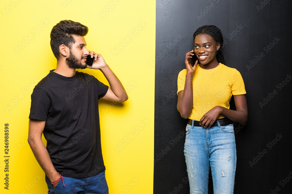 Young couple, indian man and african woman talking on the phone ...
