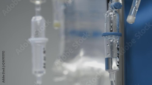 Dropper close-up with dripping medicine in operating room of modern hospital. Medicine concept.