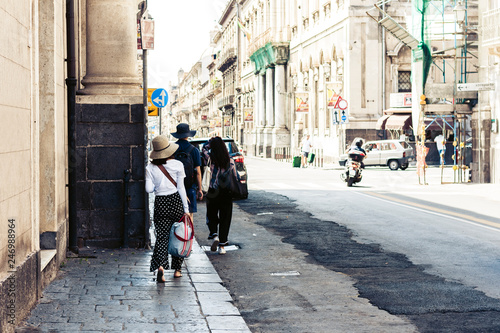 People walk on historical street of Catania, Sicily, Italy. © Inna